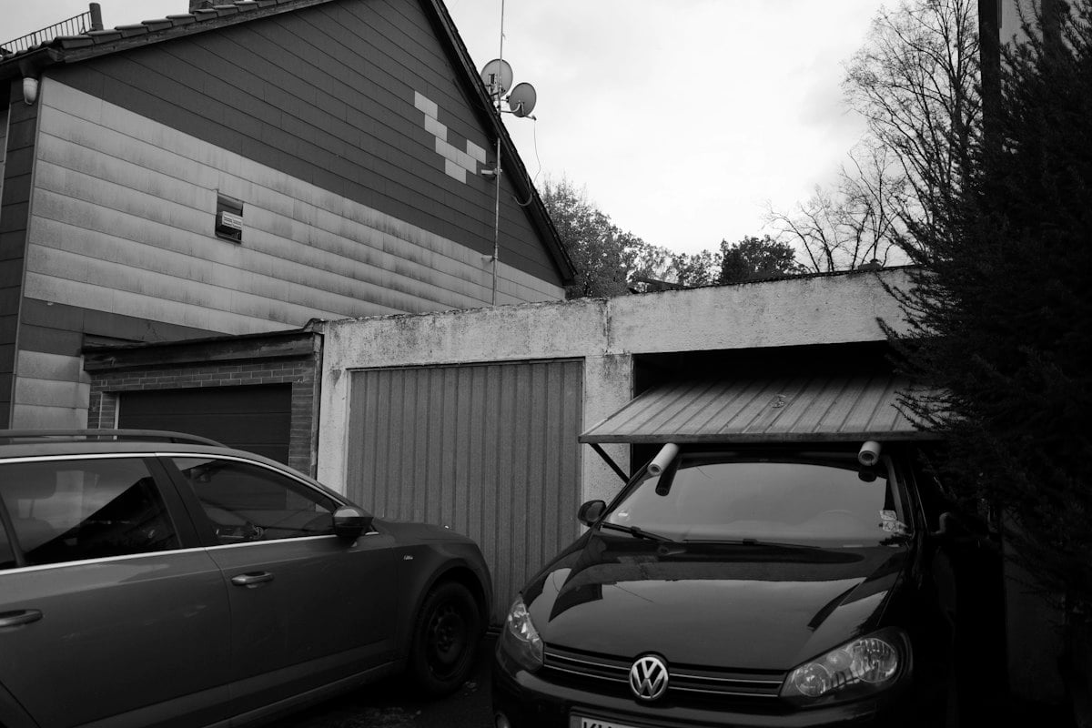 Cars parked in front of a row of small garages